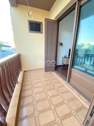 Hall de entrada com piso de cerâmica e porta de madeira em um imóvel no Brasil.