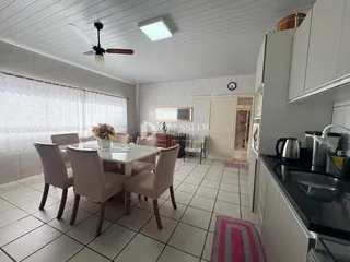 Sala de jantar com mesa e cadeiras em um imóvel no Brasil.