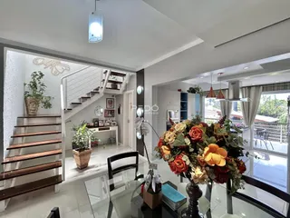 Ambiente interno com escadaria e decoração em uma sala de estar.