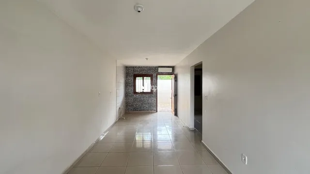 Corredor interno de uma residência com piso de cerâmica.