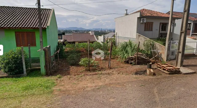 Vista externa de uma propriedade com terreno e cercas rústicas