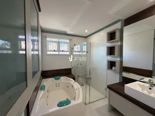 Banho com banheira e box de vidro em um imóvel no Brasil.