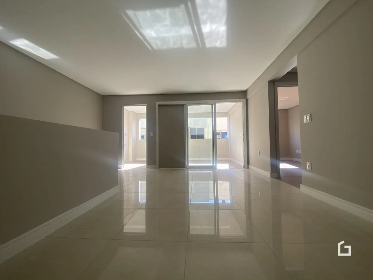 Hall de entrada com piso reflexivo e paredes claras.