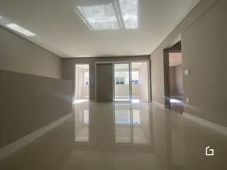 Hall de entrada com piso reflexivo e paredes claras.