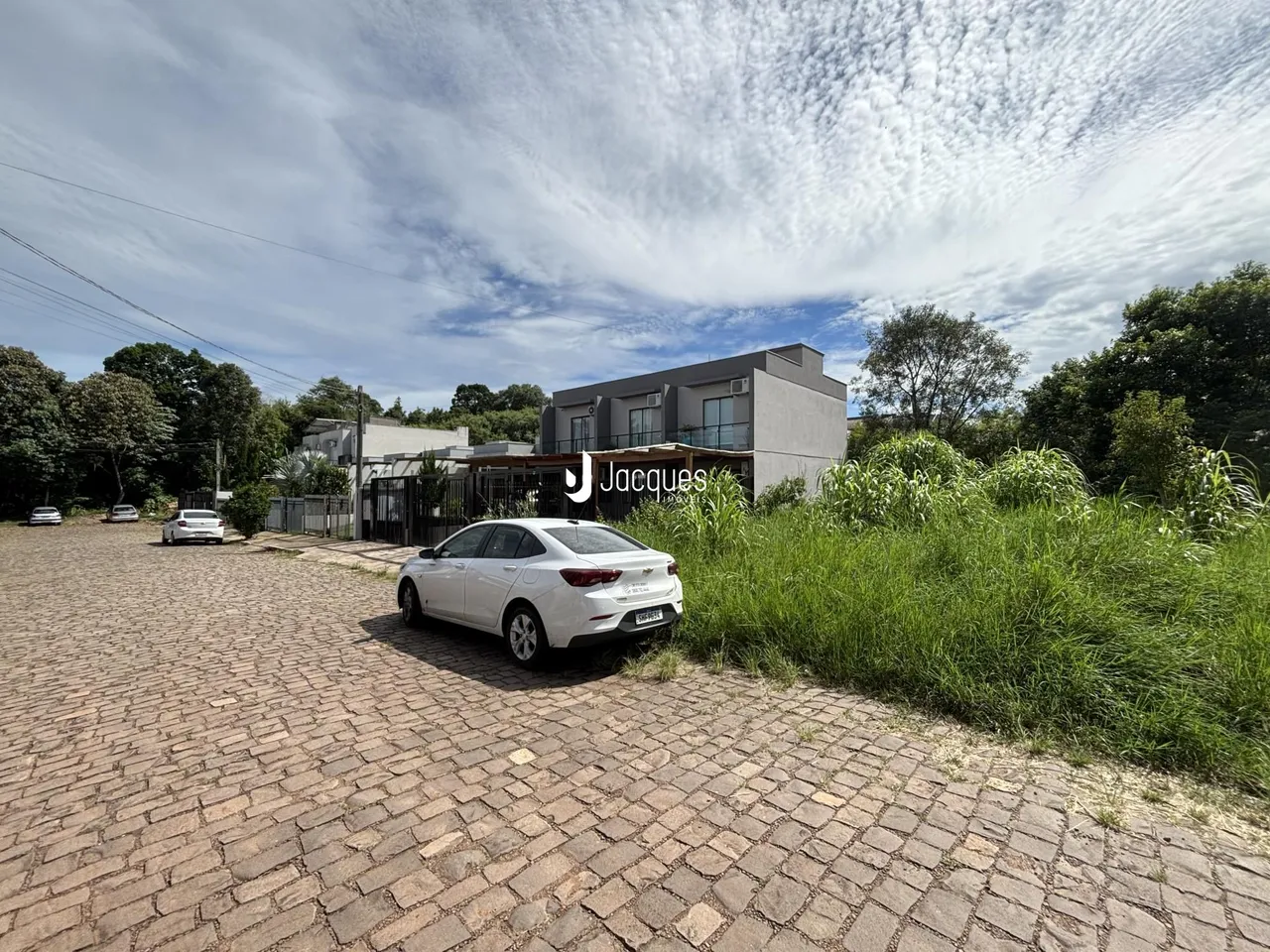 Fachada de uma residência em Lajeado, Brasil, com grama alta na frente.
