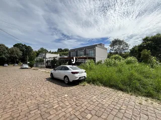 Fachada de uma residência em Lajeado, Brasil, com grama alta na frente.