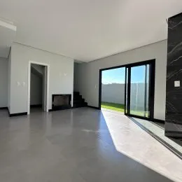 Ambiente interno com piso cinza e porta de vidro que dá para o exterior.
