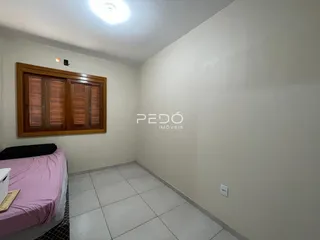 Quarto com cama e janela de madeira em um imóvel no Brasil.