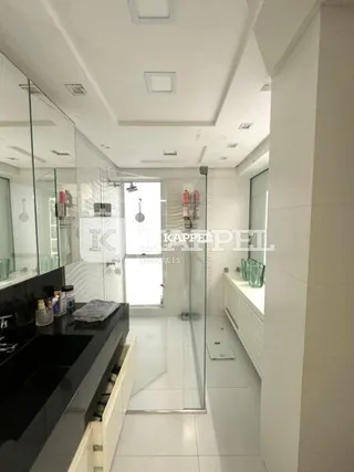 Hall de entrada com paredes brancas e piso claro.