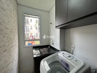 Foto de uma área de cozinha com pia e máquina de lavar roupa.