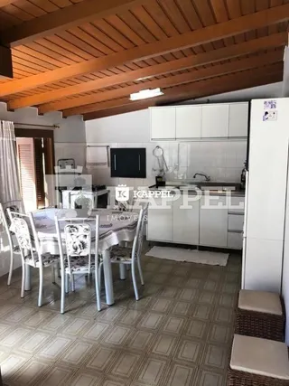 Foto de uma sala de jantar com mesa e cadeiras brancas em um ambiente interno.