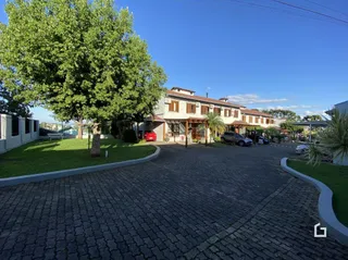 Fachada de uma residência em Lajeado, Brasil com jardim e calçada de tijolos.