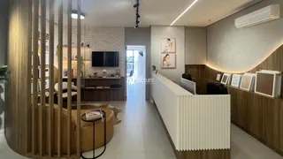 Sala de estar moderna com decoração em madeira clara e paredes brancas.