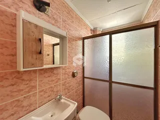 Foto de um banheiro com paredes em tons de rosa e azulejos.