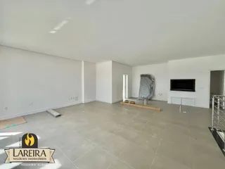 Ambiente interno de uma sala grande com piso de cerâmica.