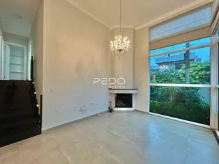 Sala de estar com lareira e grandes janelas.