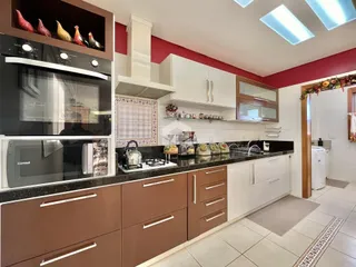 Foto de uma cozinha moderna com armários e bancadas em tons de marrom e branco.