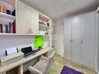 Interior de um cômodo com estantes e armários brancos.