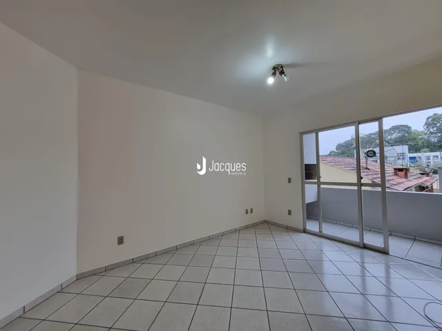 Interior de uma sala com piso de cerâmica e grandes janelas.