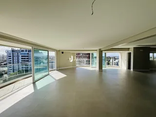 Ambiente interno amplo com portas de vidro voltadas para a vista da cidade.