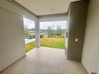 Vista de uma área interna com abertura para um jardim gramado.