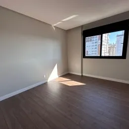 Sala de estar com piso de madeira e paredes claras.