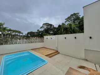 Vista de uma piscina e deck ao ar livre em uma propriedade no Brasil.