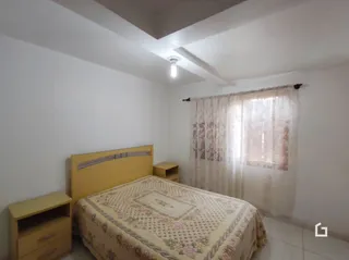 Quarto com cama e janela em ambiente interno.
