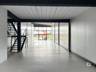 Hall de entrada com escada e portas de vidro.