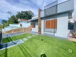 Fachada de uma casa moderna com jardim gramado em Lajeado, Brasil.
