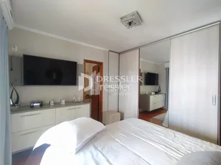 Quarto com cama e espelho em ambiente claro.