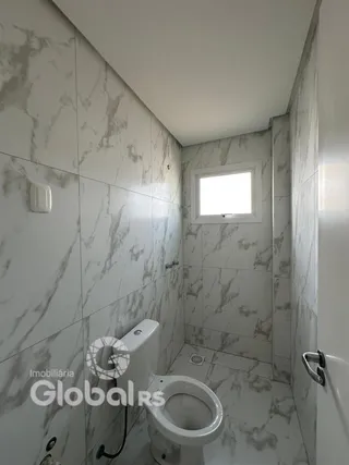 A foto mostra o interior de um banheiro com revestimento de mármore.
