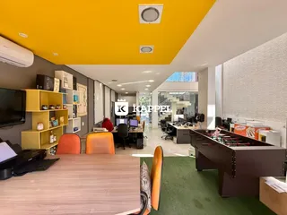 Ambiente de escritório com mesa de madeira e decoração moderna.