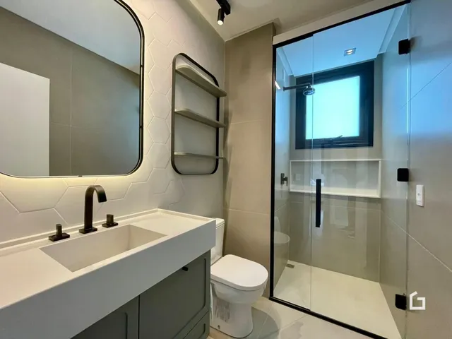 Foto de um banheiro moderno com box de vidro e bancada branca.