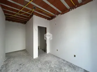 Vista interna de um ambiente com teto de alvenaria exposto.