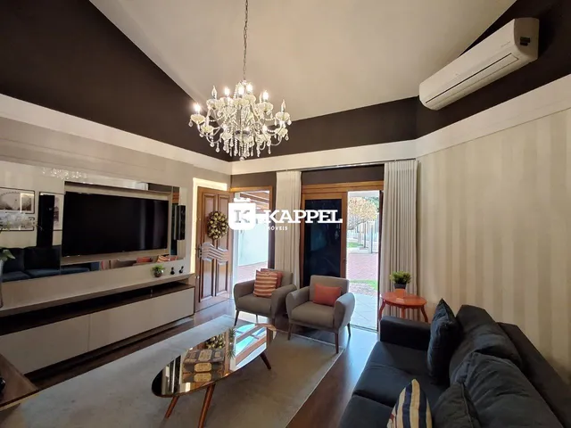 Sala de estar com sofá e televisão em ambiente com piso de madeira.