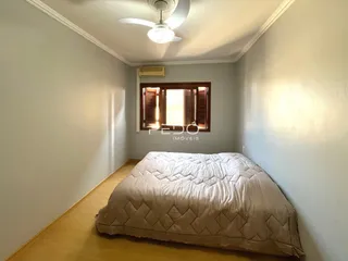 Quarto com cama e janela em ambiente claro.