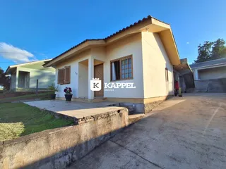 Fachada de uma casa térrea em Lajeado, Brasil, com revestimento claro e telhado de telhas.