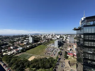 Vista aérea de uma área urbana em Lajeado, Brasil, mostrando residências e um arranha-céu.