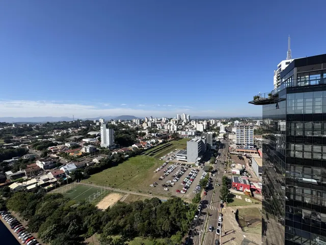 Vista aérea de uma área urbana em Lajeado, Brasil, mostrando residências e um arranha-céu.