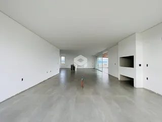 Interior de um espaço amplo com paredes brancas e piso de concreto.