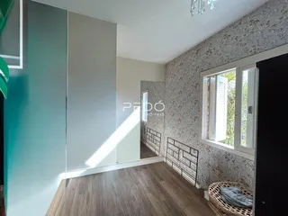 Interior de um ambiente com piso de madeira e parede decorada em Lajeado.