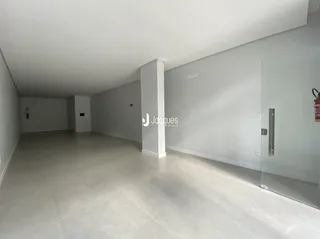 Espaço interno amplo com paredes brancas e piso claro.