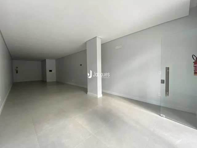 Espaço interno amplo com paredes brancas e piso claro.