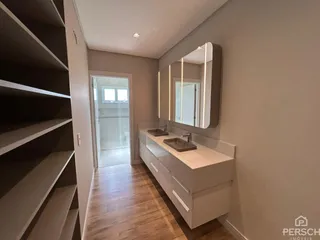 Corredor com bancada de apoio e espelho em um imóvel residencial.