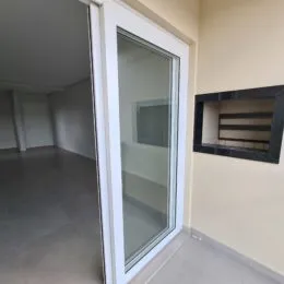 Vista interna de um corredor com paredes claras e piso neutro.