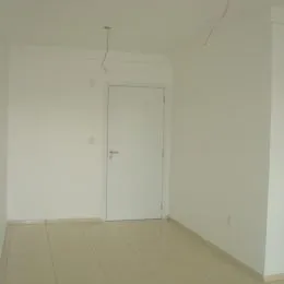 Foto de um corredor interno com paredes brancas e uma porta.