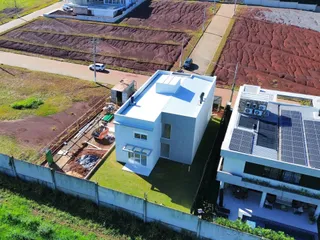 Vista aérea da fachada de uma residência moderna em Lajeado, Brasil, mostrando o terreno ao redor.