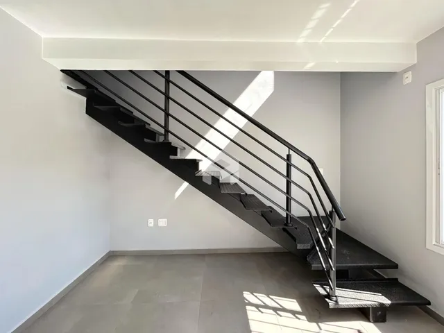 Foto de um corredor com escadaria em um imóvel.