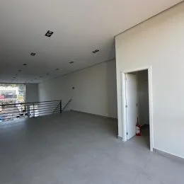 Foto de um espaço interno amplo com piso de concreto e paredes brancas.